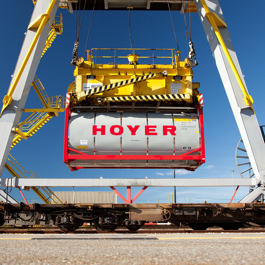 HOYER 化学品 容器 铁路 装卸 起重机 码头 HOYER 化学罐式集装箱在工业铁路终端被黄色起重机装上铁路车皮