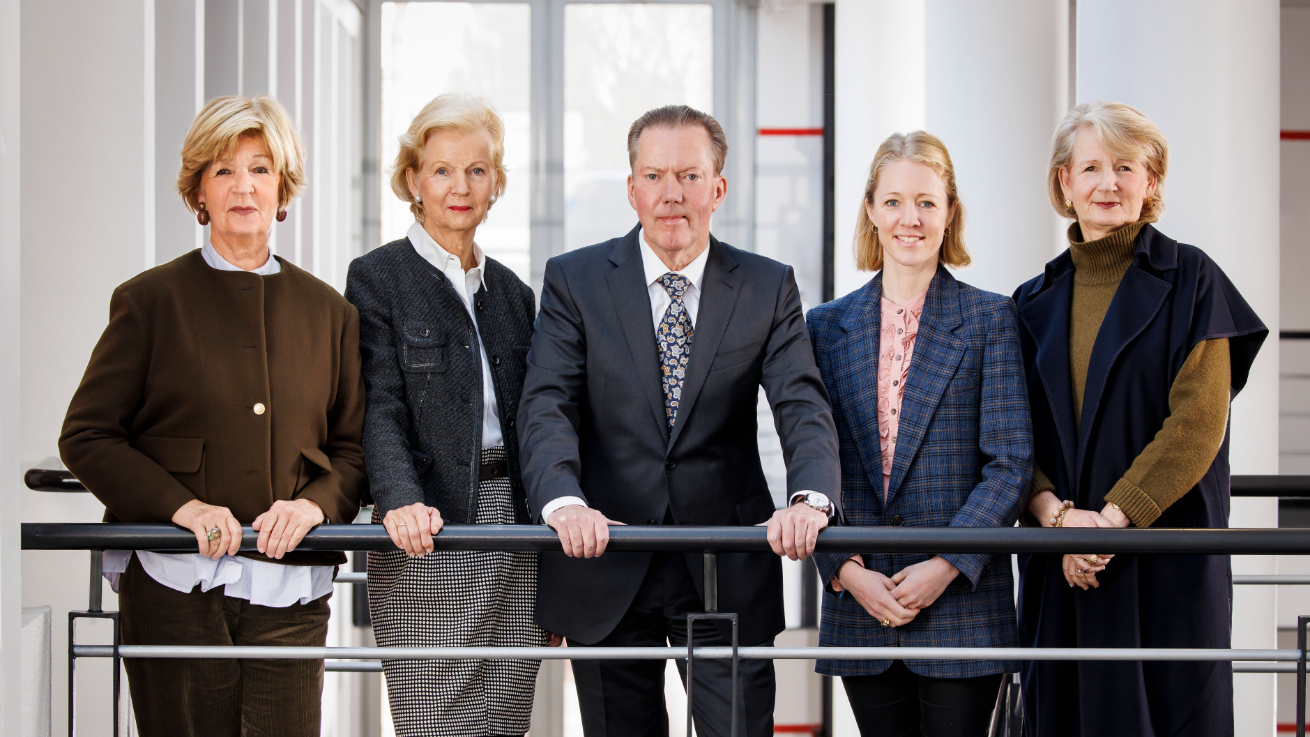 Friedel 和 Walter Hoyer 基金会理事会成员在现代建筑中的栏杆后方合影