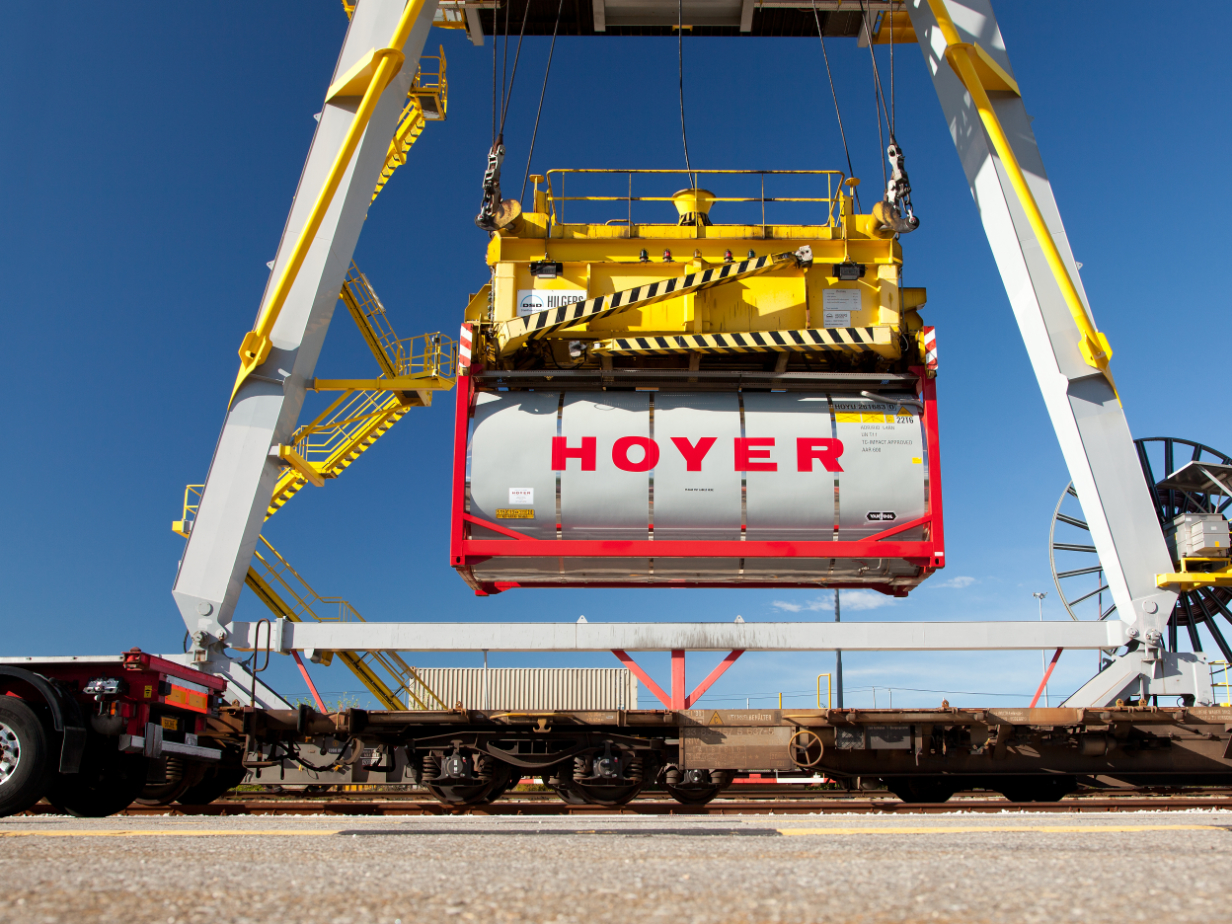 HOYER 化学品 容器 铁路 装卸 起重机 码头 HOYER 化学罐式集装箱在工业铁路终端被黄色起重机装上铁路车皮