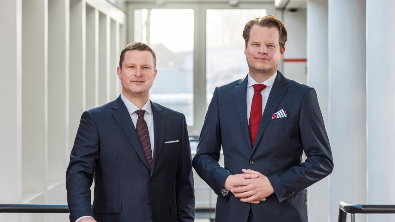 HOYER 执行董事会成员站立于现代建筑的栏杆后方